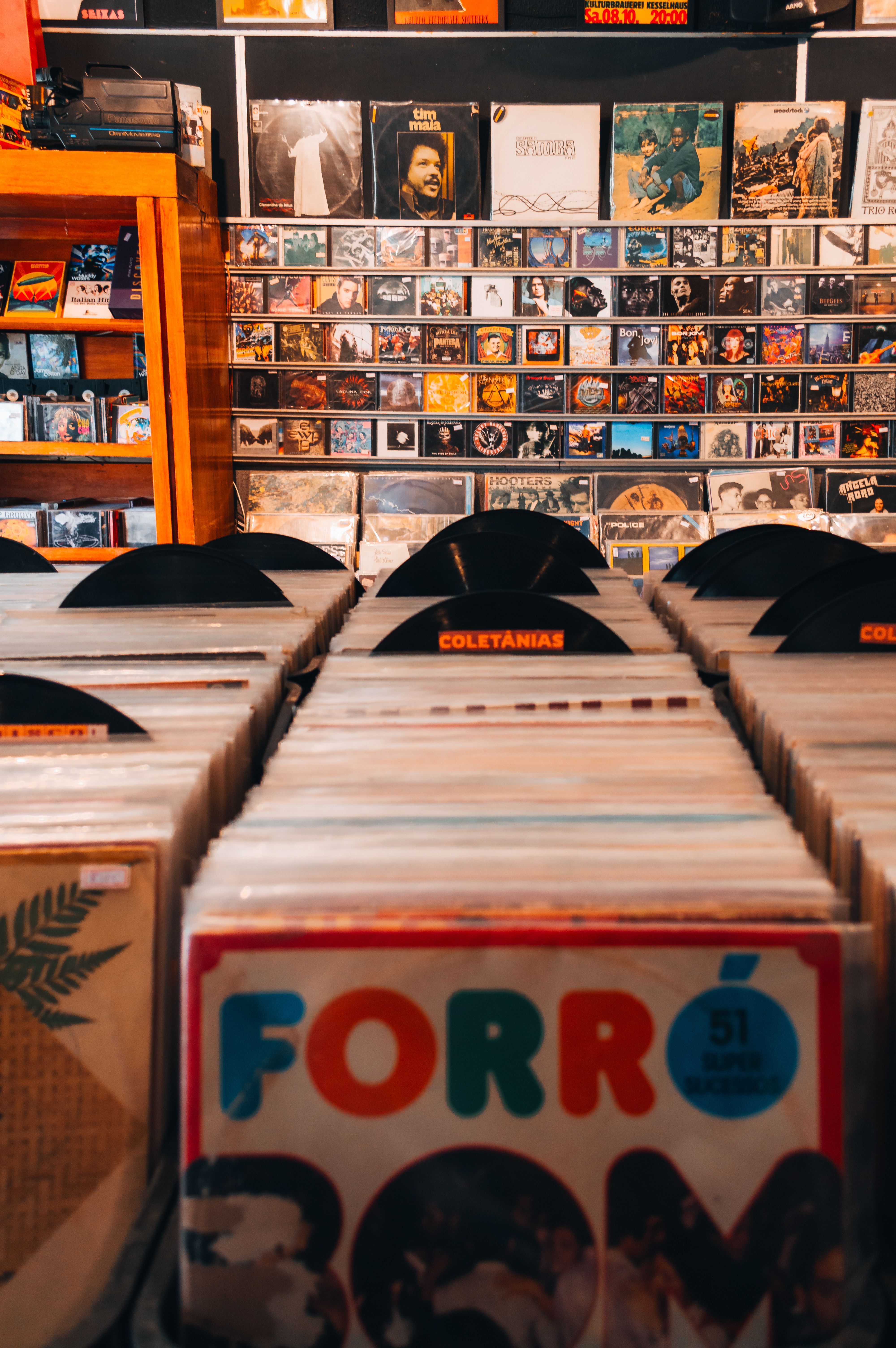 Crates of vinyl in a record shop, a wall of records behind them
